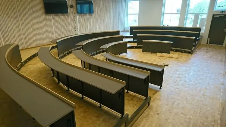 Svängda bänkrader i hörsal under montage