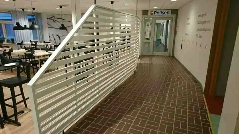 Väggsektion med vita spjälor i korridor