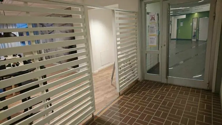 Väggsektion med vita spjälor mot glasparti