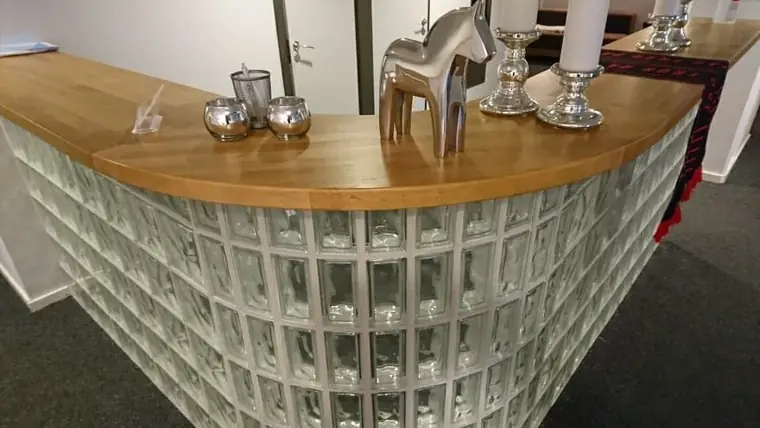Reception med svängd front i spjälmönster och skiva i trä