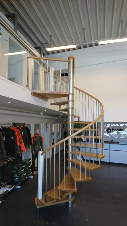 Spiraltrappa i trä och metall i öppet kontorslandskap