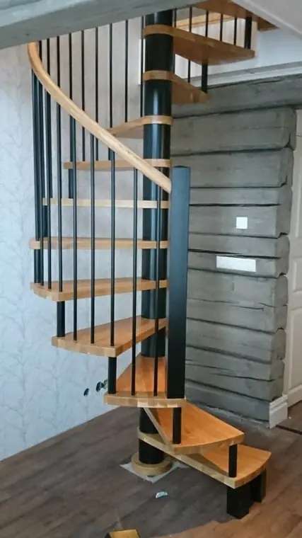 Spiraltrappa i trä med svart mittstolpe