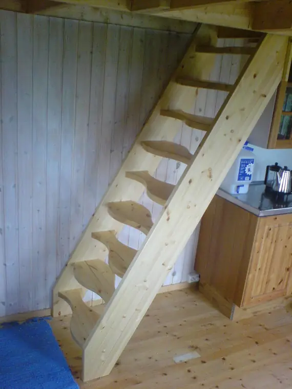Rak trappa i furu mot mörk träpanel
